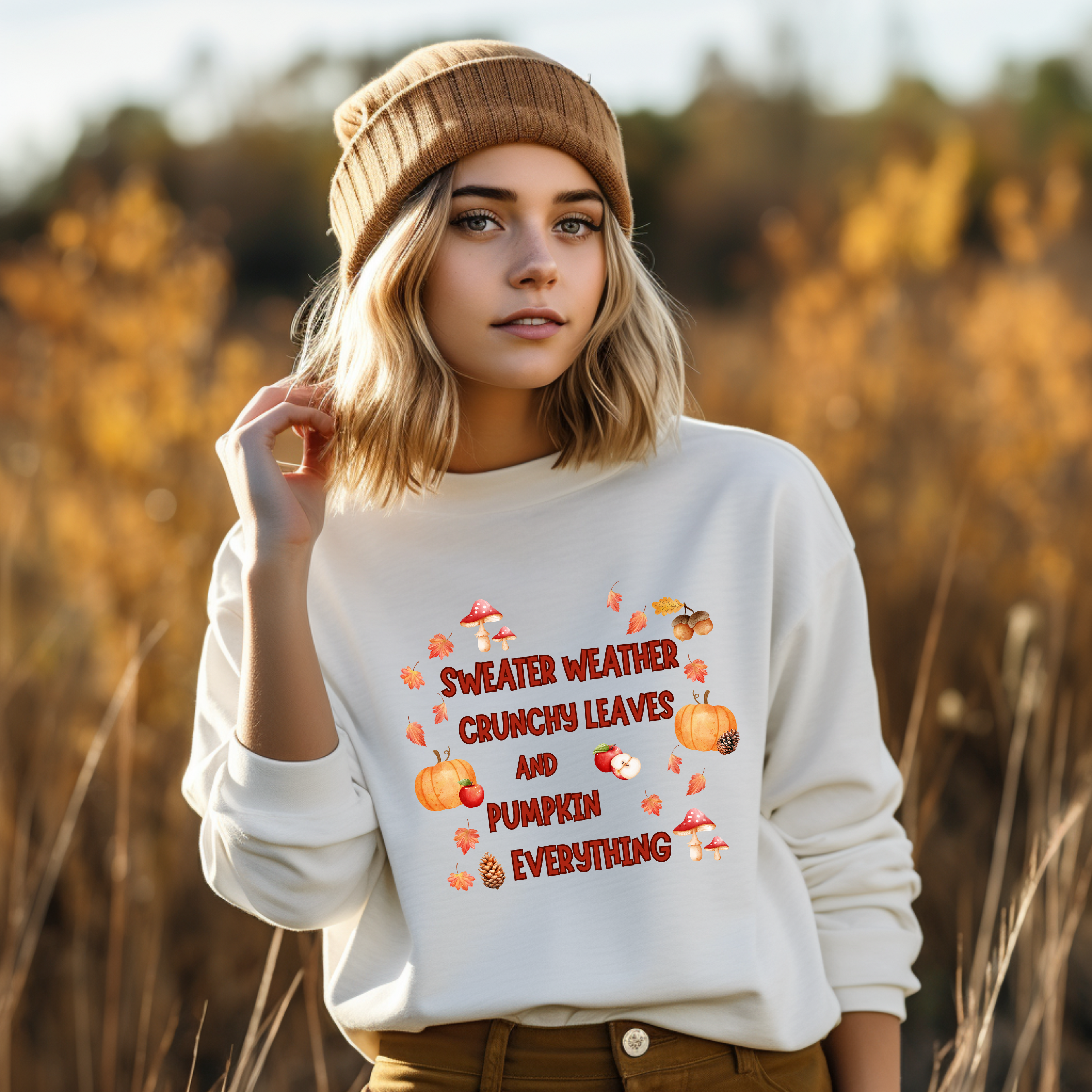 Herbstliches Sweatshirt mit dem Schriftzug ‚Sweater Weather, Crunchy Leaves and Pumpkin Everything‘, umrahmt von bunten Blättern, Kürbissen, Pilzen, Eicheln und Äpfeln – gemütlich und stimmungsvoll