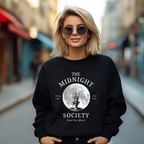 Schwarzes Halloween-Sweatshirt mit mystischem Motiv: Eine brennende Kerze im Lineart-Stil vor einem großen Vollmond, darunter der Schriftzug ‚THE MIDNIGHT SOCIETY – telling tales, after dark‘. Design mit Retro- und Gruselflair.
