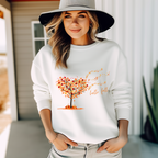 Sweatshirt mit Motiv eines geschwungenen Herbstbaums im Wind, dessen orange-, gelb- und rostrote Blätter durch die Luft wirbeln. Darunter handschriftlicher Schriftzug ‚hello fall‘. Romantisches, stimmungsvolles Herbstdesign