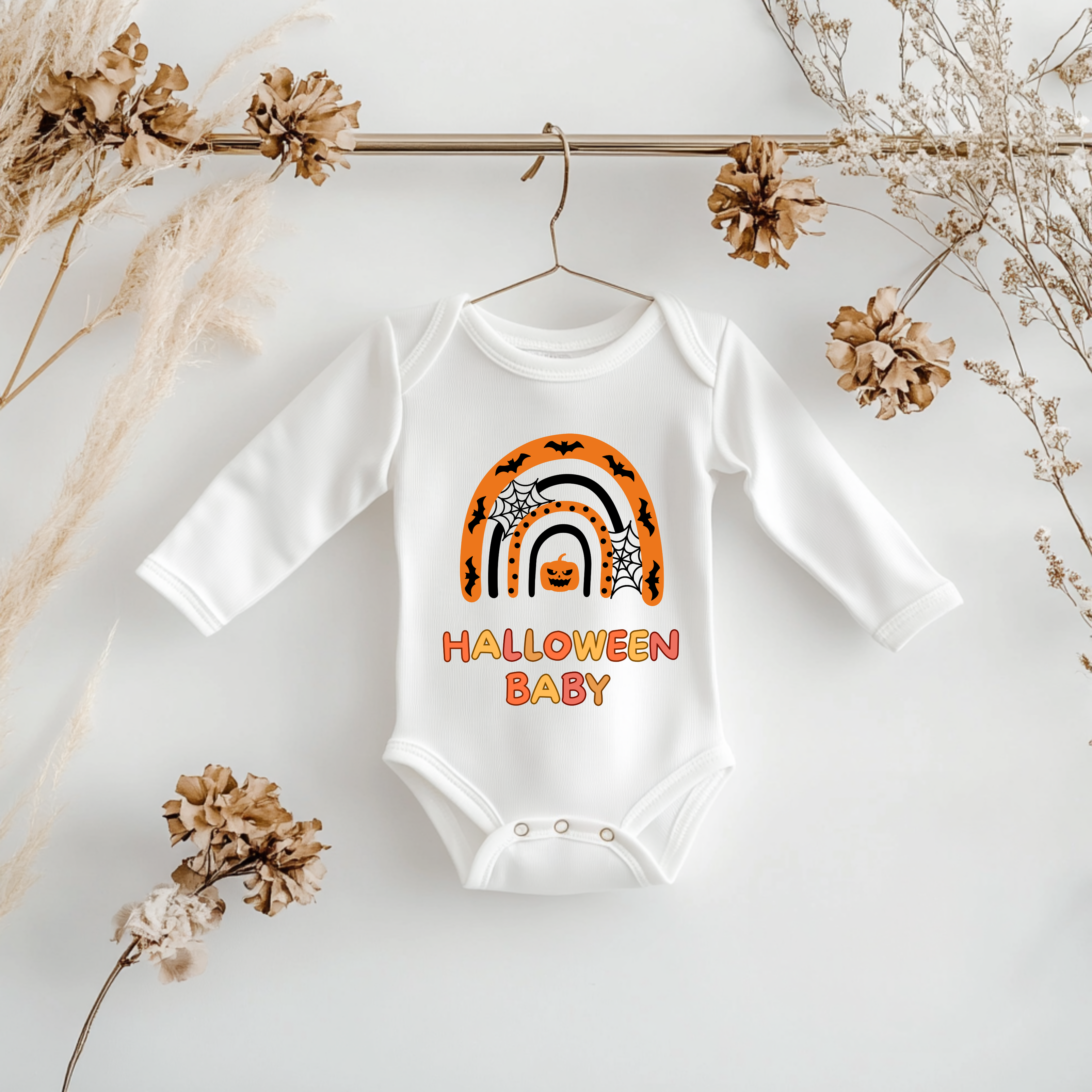 Weißer Langarm Baby-Strampler mit Halloween-Motiv: bunter Regenbogen in Orange- und Schwarztönen, darunter der Schriftzug ‚Halloween Baby‘.