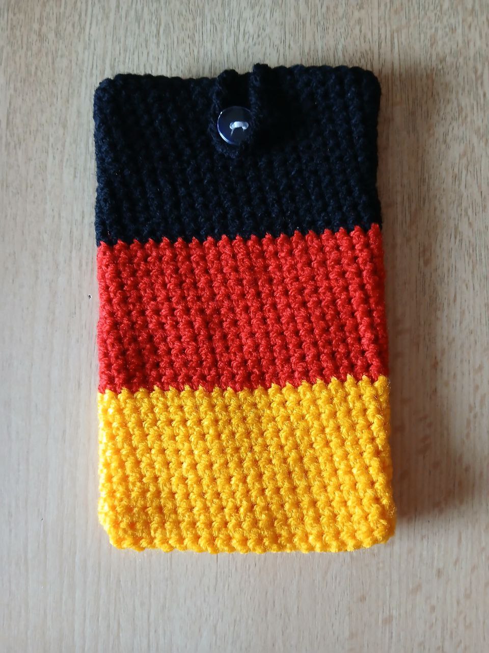 Handgehäkelte Handyhülle in Deutschlandfarben – mit praktischem Knopfverschluss – in zwei Größen: 10 x 16 cm und 10 x 18 cm